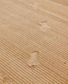 Shoe footprints in rippled sand on beach