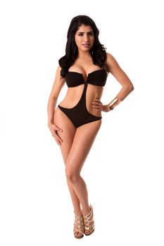 Beautiful young brunette woman in sexy black bikini standing, isolated.