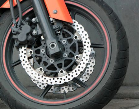 Close up of the front wheel of a red motorbike