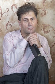 Portrait of middle-aged man reading a book in the black cover at home