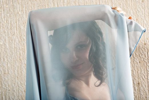 Portrait of a pretty woman with the face hidden under a veil