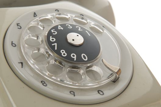 a closeup of an old gray phone dialing ring