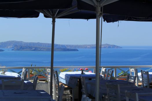View on the volcano and Aegean sea from a terrace restaurant at Oia, Santorini island, Greece