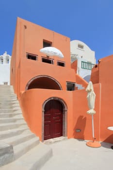 Colorful house next to stairs in Oia by beautiful waether, Santorini, Greece