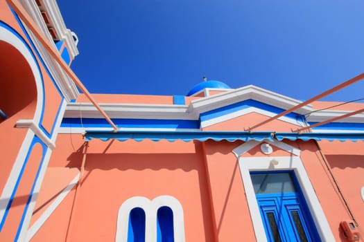 Close up of colorful orthodox church with typical architecture and blue dome in Oia, Santorini island, Greece