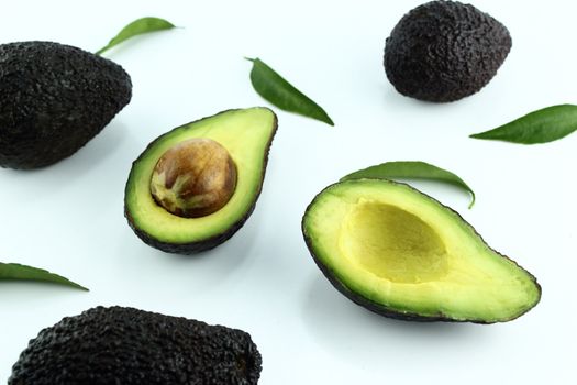 Black Ripe Avocados with leaves on white Background.