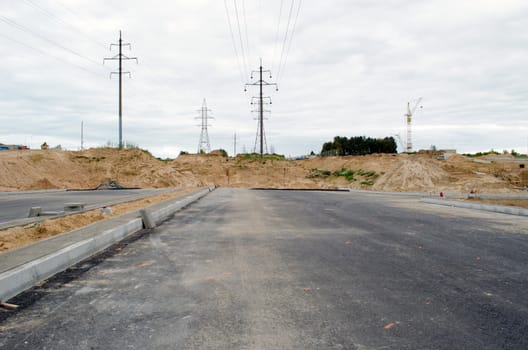 building highway asphalt road construction site. high voltage electricity line.