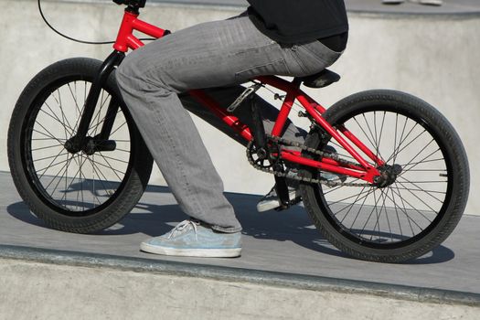 Boy sitting on his bike having a little rest at the skate park