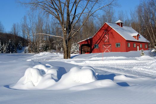 Red barn covered with fresh snow