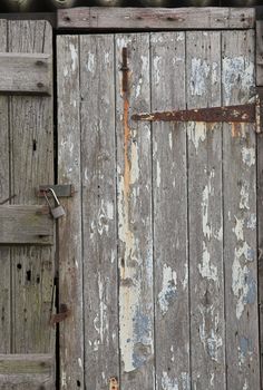 Detail of an old wooden shed locked with a padlock