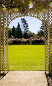 View of a beautiful garden from under a pergoll.