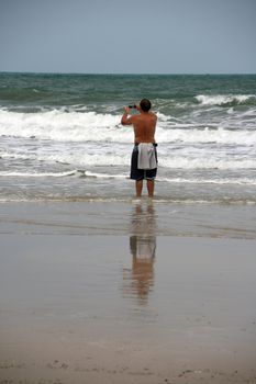 man shooting the waves on white sand beach koh chang island thailand