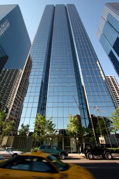 Glasse facade and yelow cab