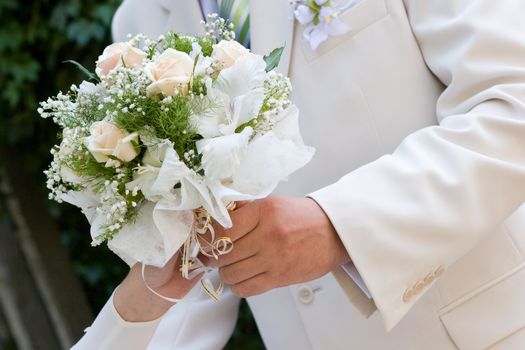 wedding bouquet in hands of bride and  groom