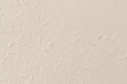 Cream textured paper closeup, can be used as a background.