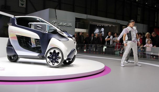 GENEVA - MARCH 8 : battery-powered electric i-Road Toyota concept car and dancers to present it on display at the 83st International Motor Show Palexpo - Geneva on March 8, 2013 in Geneva, Switzerland.
