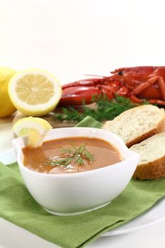 a bowl of lobster soup with dill and lemon