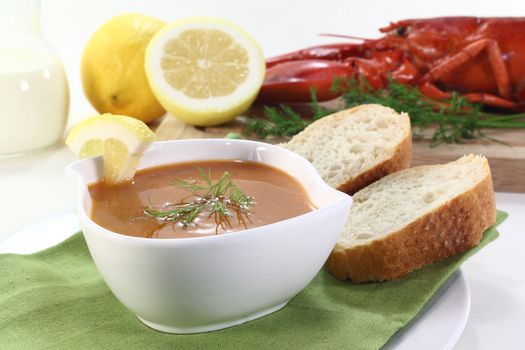 a bowl of lobster soup with dill and lemon