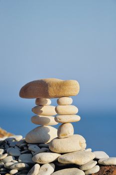 Long horizontal stone between a piles of pebble