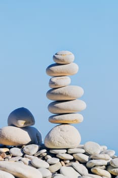 Balancing white pebbles each other on the seacoast