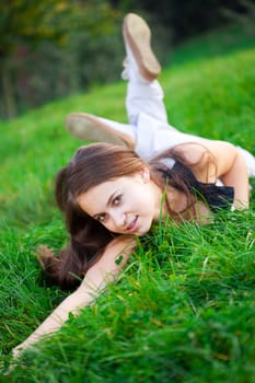 beautiful young woman lying on green grass