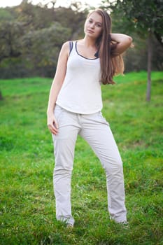 beautiful young woman standing on green grass