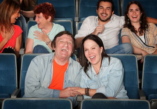 Groups of friends in the audience laugh and smile