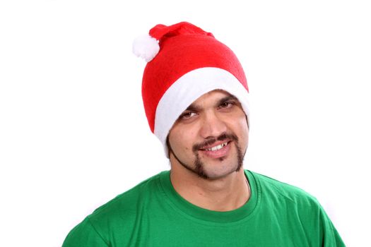 A young Indian guy wearing a santa hat during Christmas in India, on white studio background.