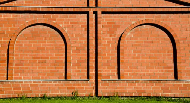 Background of decorative red brick wall with arch imitation.