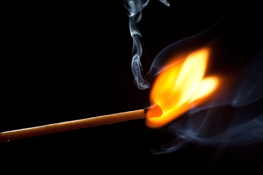 Burning match on a black background 