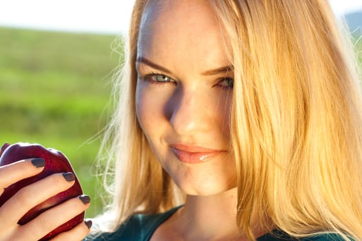 portrait of a beautiful young woman with apple  outdoor