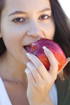 portrait of a beautiful young woman with apple  outdoor