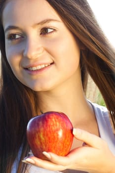 portrait of a beautiful young woman with apple  outdoor