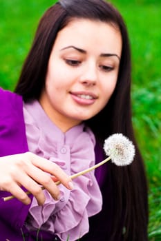 portrait of a beautiful young woman with dandelion