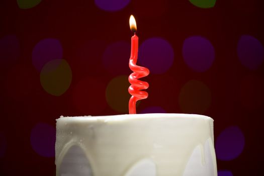 happy birthday cake shot on a red blurred background with candles