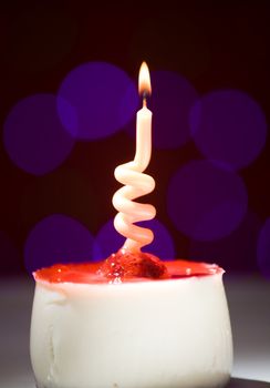 happy birthday cake shot on a red blurred background with candles