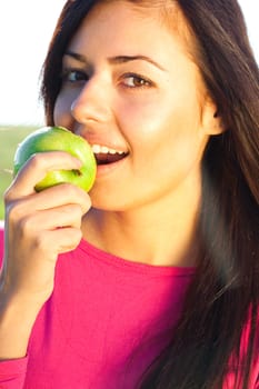 portrait of a beautiful young woman with apple  outdoor