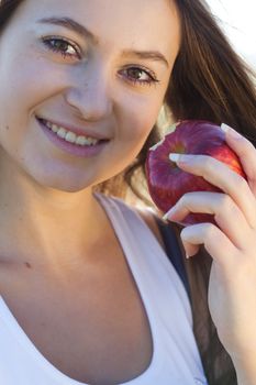 portrait of a beautiful young woman with apple  outdoor