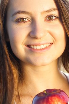 portrait of a beautiful young woman with apple  outdoor