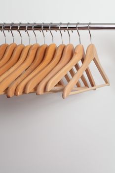Photo of empty wooden clothes hangers in a retail store.