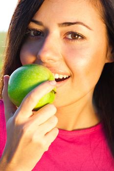 portrait of a beautiful young woman with apple  outdoor