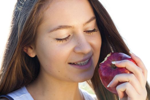 portrait of a beautiful young woman with apple  outdoor
