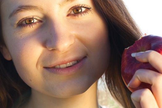 portrait of a beautiful young woman with apple  outdoor