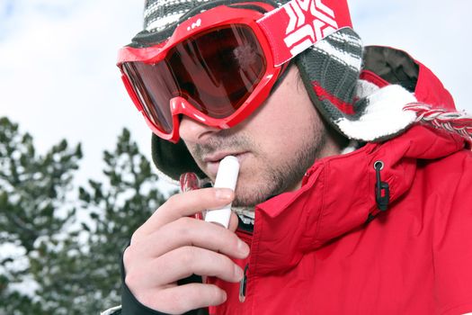 Skier applying lip balm