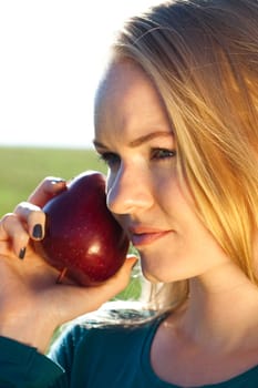 portrait of a beautiful young woman with apple  outdoor