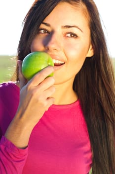 portrait of a beautiful young woman with apple  outdoor