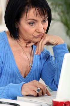 Annoyed woman looking at her laptop