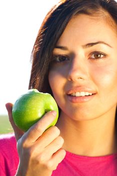 portrait of a beautiful young woman with apple  outdoor