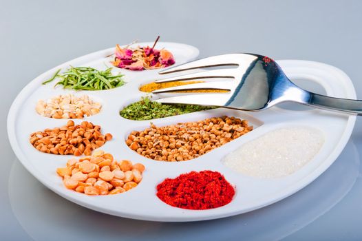 The palette of spices and groceries with a fork