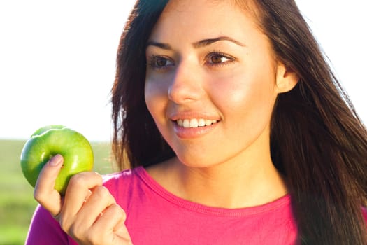 portrait of a beautiful young woman with apple  outdoor